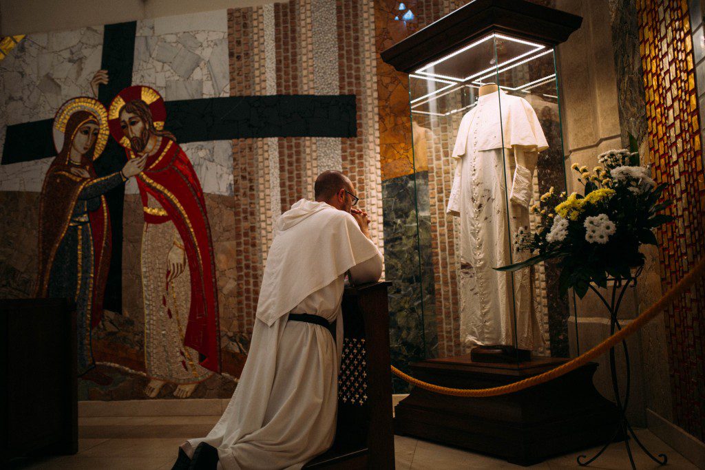 Fr. James Cuddy, O.P. prays in front of the cassock worn by Saint John Paul II when he was shot on the Feast of Our Lady of Fatima; this photo was taken at the Saint John Paul II Sanctuary in Krakow, Poland.